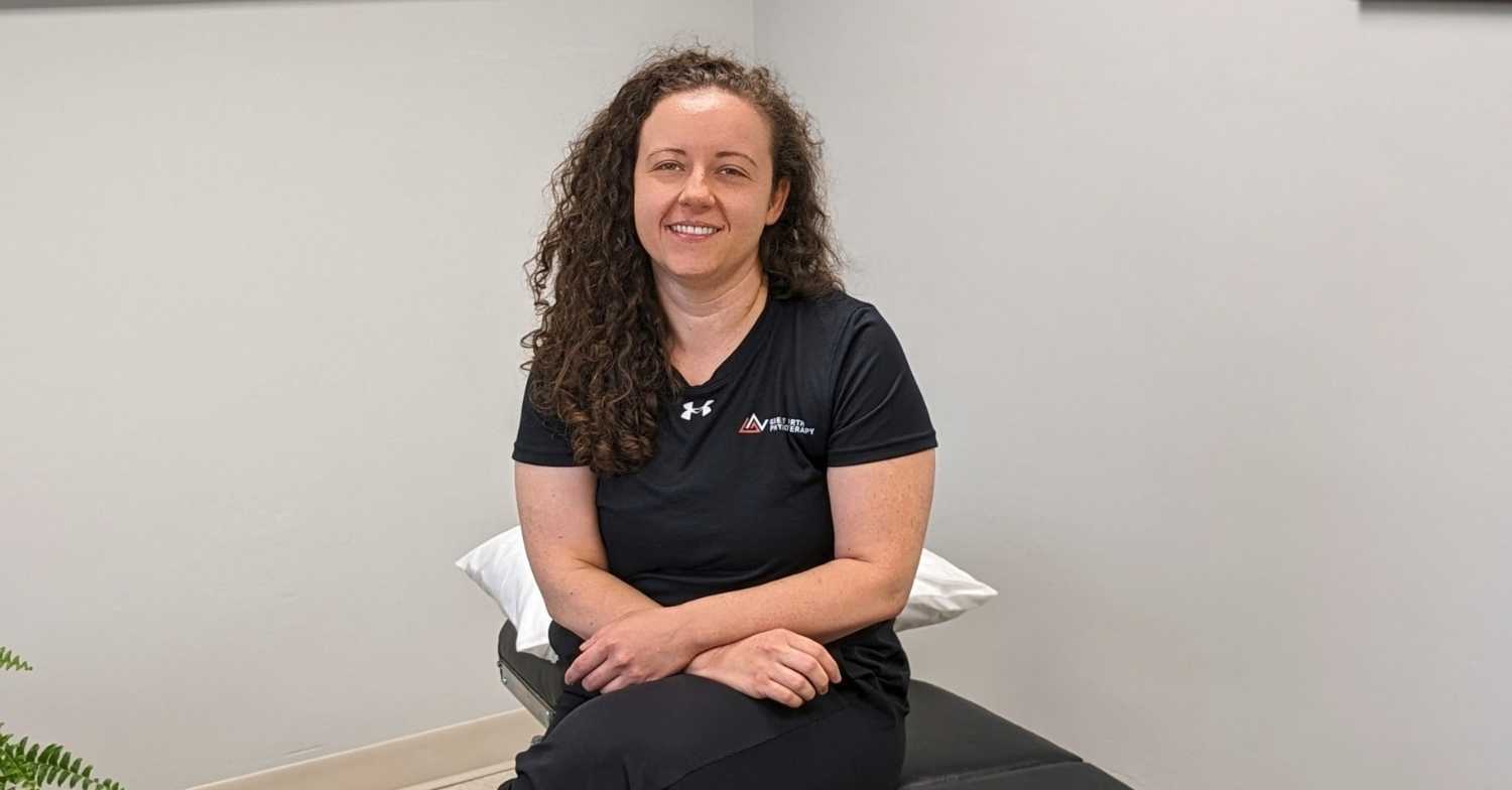 Dr. Jessica Toth sitting on her chiropractic table