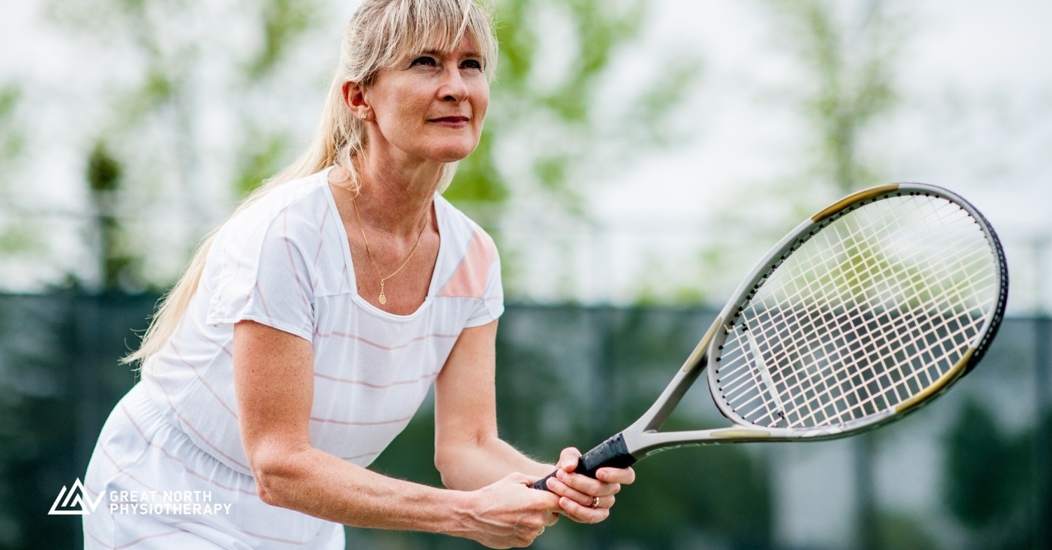an older female athlete is getting ready to receive a serve during a tennis match